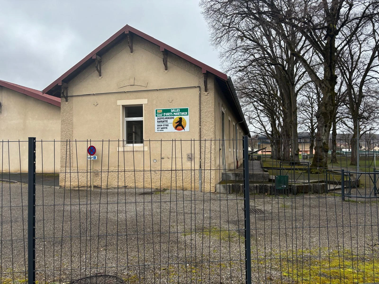 Photo de l'extérieur du dojo devant les places de parking